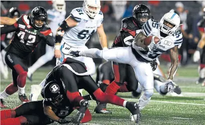  ?? JUSTIN TANG THE CANADIAN PRESS ?? Argonauts running back Brandon Burks leaps past Redblacks defensive back Devin Butler on Friday in Ottawa.