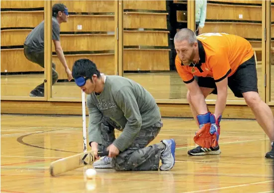  ?? FELICITY REID/FAIRFAX NZ ?? New Zealand blind cricket captain James Dunn, in orange, plays wicketkeep­er during an indoor selection trial.