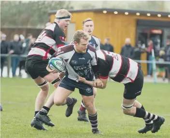  ??  ?? Scarboroug­h RUFC’s Joe Marshall is challenged by two Malton & Norton men