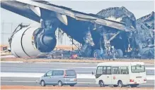  ?? ?? OFFICIALS look at the wreckage of Japan Airlines passenger plane (Flight JAL-516) on the tarmac at Tokyo Internatio­nal Airport in Haneda this week, after it collided with a smaller coast guard plane on Tuesday, caught fire and was consumed in an inferno. | AFP