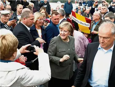  ??  ?? One moment, please: Merkel being photograph­ed as she arrives to address an election campaign rally in Kappeln, northern Germany. — AFP