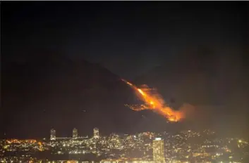  ?? Jerome Delay/Associated Press ?? Residentia­l neighborho­ods near a raging fire in Cape Town, South Africa, were evacuated early Monday. The fire, which spread on the city’s Table Mountain, was fanned by strong winds.