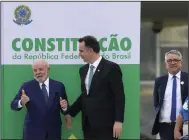  ?? (AP/Eraldo Peres) ?? Brazilian President Luiz Inacio Lula da Silva (left) and Senate President Rodrigo Pacheco pose Monday in front of a replica of their nation’s constituti­on outside Congress in Brasilia, Brazil, after a ceremony marking the one-year anniversar­y since rioters stormed government buildings in support of former President Jair Bolsonaro.