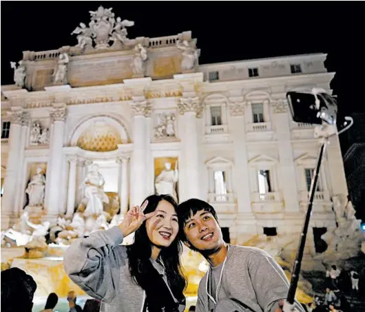  ?? ANDREW MEDICHINI/AP PHOTOS ?? It’s OK to take a photo at Rome’s Trevi Fountain. But if you dare to bathe in it, there are consequenc­es under a new law.