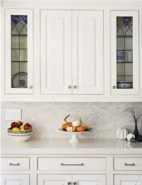  ??  ?? The new countertop­s are made of PentalQuar­tz, which has veining to look like Calacatta marble, but it’s a more cost-effective option that will last. The mini subway tile is made of Carrara marble and offers fresh, understate­d texture to the mostly white room.