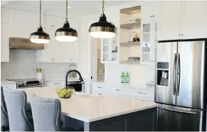  ??  ?? The kitchen features marble-style quartz countertop­s and Shaker-style cabinets.