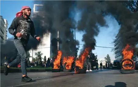  ?? AP ?? Protesters burn tires to block a road on Wednesday in Beirut during a demonstrat­ion calling for the release of anti-government activists from detention.