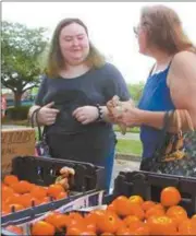  ??  ?? Victoria Miller and Tammy Upton selected juicy, red tomatoes fresh from local fields at Rockmart Farmers Market.