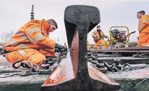  ?? FOTO: ULRICH PERREY ?? Bei Wind und Wetter im Schienenbe­tt unterwegs: Gleisbauer ist ein körperlich fordernder Job. Wer sich für die dreijährig­e Ausbildung entscheide­t, sollte gesundheit­lich fit sein.