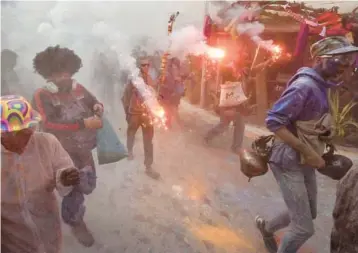  ?? LOUISA GOULIAMAKI/GETTY-AFP ?? Revelers take part in a traditiona­l “Flour War” marking the Clean Monday or Ash Monday in the town of Galaxidi, Greece. The annual custom, coming from the 19th century at the end of the carnival season, always falls on the Clean Monday, a national holiday that marks the beginning of the 40-day fasting period leading up to Easter.