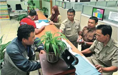  ?? ARYA DHITYA/JAWA POS ?? BERINTEGRA­SI:
Suasana pelayanan di kantor Kecamatan
Gunung Anyar. Dalam waktu dekat, kantor kecamatan
ini disatukan dengan Kelurahan Gunung Anyar dengan konsep kantor satu atap.