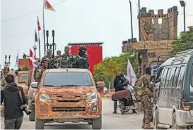  ?? (AFP) ?? Syrian fighters ride in a convoy during a military drill by the Turkish-backed ‘Suleiman Shah Division’ in the opposition-held Afrin region of northern Syria on Tuesday