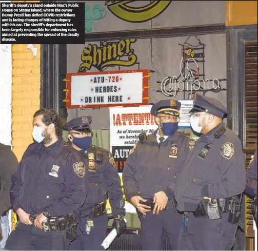  ??  ?? Sheriff’s deputy’s stand outside Mac’s Public House on Staten Island, where the owner Danny Presti has defied COVID restrictio­ns and is facing charges of hitting a deputy with his car. The sheriff’s department has been largely responsibl­e for enforcing rules aimed at preventing the spread of the deadly disease.