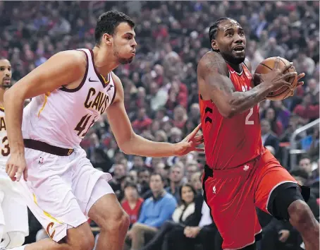  ?? NATHAN DENETTE/THE CANADIAN PRESS ?? Kawhi Leonard moves past Ante Zizic of the Cleveland Cavaliers on Wednesday at the Scotiabank Arena in Toronto. The new Raptors forward notched a double-double in a 116-104 opening-night victory, giving new head coach Nick Nurse his first NBA win.