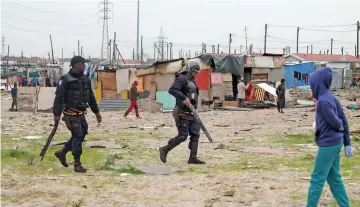  ?? PICTURES: SISONKE MLAMLA ?? TAKING ACTION: Law enforcemen­t officers monitor the illegally occupied area.
