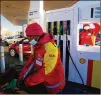  ?? THEMBA HADEBE/AP ?? A fuel attendant fills up a vehicle ahead of a fuel price hike Tuesday in Soweto, South Africa. Gas is more than $5.80 per gallon.