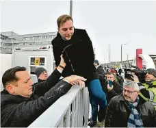  ?? FOTO ČTK/AP ?? Opoziční poslanci si pomáhají přelézt plot do areálu televize MTV
