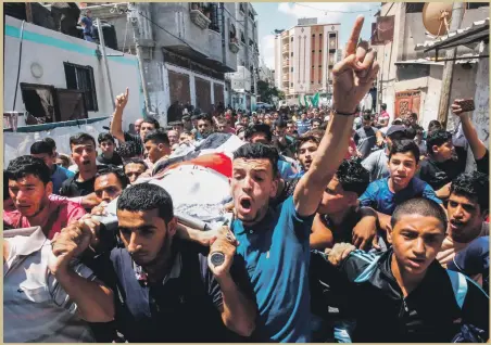  ?? AFP ?? Mourners carry the body of Palestinia­n boy Majdi Al Satari, 11, during his funeral in the Rafah refugee camp in the Gaza Strip yesterday. Majdi died of wounds after being shot by Israeli troops during protests on Friday,