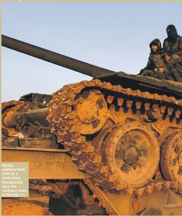  ?? AFP ?? Syrian soldiers hitch a lift on a tank being transporte­d near the northern town of Manbij