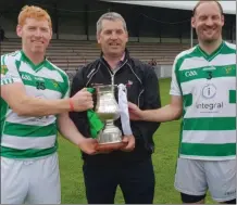  ??  ?? Louth chairman Des Halpenny presents the Division 2 trophy to Andrew Rogan and Ciaran Brassil of O Raghallaig­h’s.