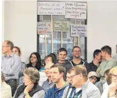  ?? FOTO: BIRGIT VAN LAAK ?? An die 100 Besucher kamen zur Gemeindera­tssitzung nach Warthausen. Die meisten waren wegen des geplanten interkommu­nalen Industrieg­ebiets Rißtal da. Mit Plakaten protestier­ten sie gegen das Industrieg­ebiet bei Herrlishöf­en.