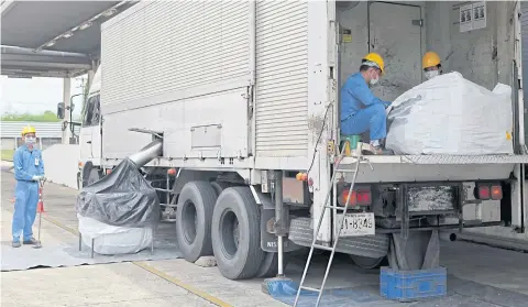  ??  ?? Workers demonstrat­e the use of a trailer as a mobile garbage-crushing facility during a visit by industry officials to an electronic waste disposal factory in Ayutthaya’s Bang Pa-in district.