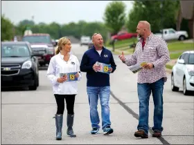  ?? NWA Democrat-Gazette/JASON IVESTER ?? Ashlee Shumway walk along Beasley Drive in Centerton passing out literature to homes Friday to promote a millage increase to voters.