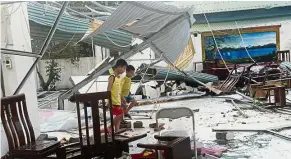  ?? — AFP ?? Broken toy: Two boys playing at a destroyed restaurant in Ky Anh town in Ha Tinh province.