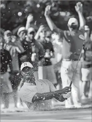  ?? JOHN AMIS/AP PHOTO ?? Tiger Woods hits from a greenside bunker on the 13th hole during Friday’s second round of the Tour Championsh­ip at East Lake in Atlanta. Woods shares the lead with Justin Rose after 36 holes at 7-under-par.