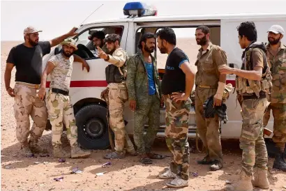  ?? AFP ?? Syrian pro-government forces stand near an ambulance in Bir Qabaqib, more than 40 kilometres west of Deir Ezzor, after taking control of the area on their way to Kobajjep on Monday. —