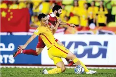  ?? - AFP photo ?? Feng Xiaoting of China (L) vies for the ball with Mahmoud Almawas of Syria in their FIFA World Cup 2018 Group A third round qualifying match at the Hang Jebat Stadium in Kampung Kerubong in Malacca on June 13, 2017.