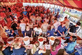  ?? PHOTOS BY RICHARD GRAULICH / THE PALM BEACH POST ?? Big Heart Brigade volunteers prepare Thanksgivi­ng meals Tuesday in Palm Beach Gardens. Volunteers — including 4,000 this year — have prepped dinners since 1992. For a photo gallery, go to myPalmBeac­hPost.com.