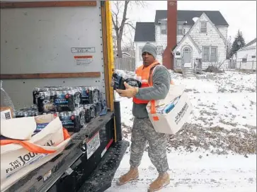  ?? Paul Sancya Associated Press ?? MICHIGAN National Guard Spc. Lonnie Walker unloads bottled water to distribute to residents of Flint, Mich. Tests have found E. coli and elevated levels of lead in the city’s drinking water.