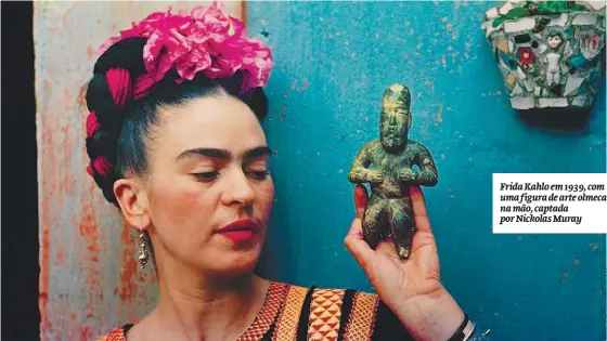  ??  ?? Frida Kahlo em 1939, com uma figura de arte olmeca na mão, captada por Nickolas Muray