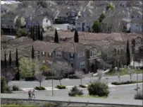  ??  ?? In this March 6, 2018, file photo, people walk along a path in front of a row of homes in San Jose, Calif. The suburbs are usually seen as the great political swing area in the United States, toggling back and forth between the two parties. But a new poll shows the suburbs are as polarized along partisan lines as the rest of the nation. AP PHOTO/ MARCIO JOSE SANCHEZ, FILE