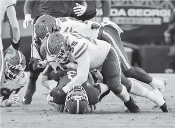  ?? CURTIS COMPTON Atlanta Journal-Constituti­on ?? Florida defensive lineman Kyree Campbell (55) flattens Georgia quarterbac­k Stetson Bennett for a first-quarter sack on Saturday. The Gators had three sacks on the day.