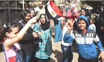  ??  ?? Egyptian women and youths dance and celebrate with national flags outside a polling station on the first day of the 2018 presidenti­al elections, in al-Haram neighbourh­ood in the capital Cairo’s southweste­rn Giza district. — AFP photo