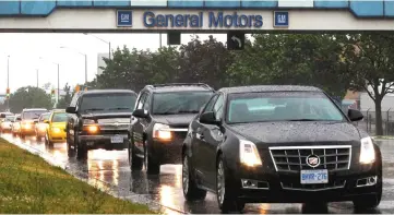  ??  ?? Cars pass under an overpass at the General Motors Car assembly plant in Oshawa. — Reuters photo