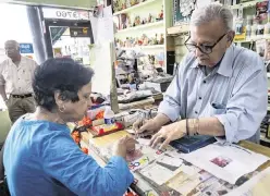 ?? JOSE A. IGLESIAS jiglesias@elnuevoher­ald.com ?? Suresh Sheth takes care of longtime customer Nirmala Prakash at the counter of the Indo American Store in West Kendall.
