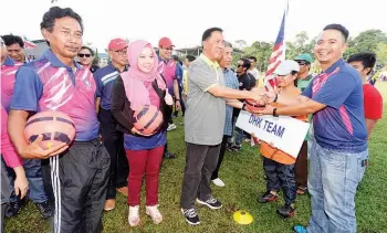  ??  ?? SAPAWI (tiga kiri) bersalaman dengan pemain dari salah satu pasukan yang mengambil bahagian.