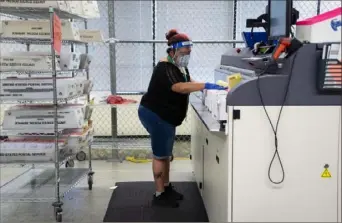  ?? Ruth Fremson/The New York Times ?? Kamisha Baseden processes mail-in ballots during the primary election in Renton, Wash., on Aug. 4.