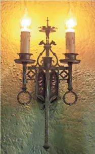  ?? MIKE DE SISTI, MILWAUKEE JOURNAL SENTINEL ?? The iron sconces that hang above the fireplace, and throughout the home, are original to the 1929 home.