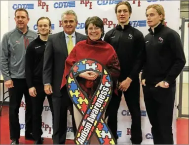  ?? MARK ROBARGE — MROBARGE@TROYRECORD.COM ?? Teri Kippen, center, mother of two children on the autism spectrum, holds an autism awareness ribbon during a Thursday morning news conference inside the Houston Field House at Pensselaer Polytechni­c Institute in Troy to announce Rensselaer County will...