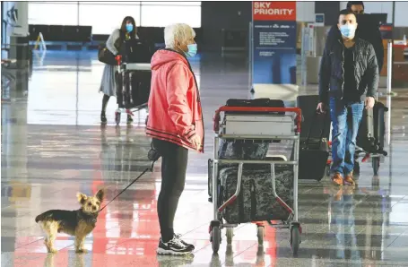  ?? GAVIN YOUNG ?? Travellers move through Calgary Internatio­nal Airport on Thursday, where rapid testing for COVID-19 is being offered.