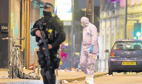  ?? AP ?? A police forensic officer looks around near the scene after a stabbing incident in Streatham London, England, yesterday. London police officers shot and killed a suspect after at least two people were stabbed Sunday in what authoritie­s are investigat­ing as a terror attack.