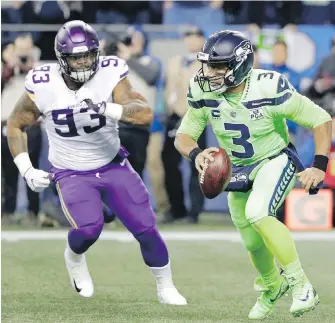  ??  ?? Seahawks quarterbac­k Russell Wilson scrambles away from Vikings defender Sheldon Richardson during the first half in Seattle on Monday night.