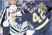  ?? AP ?? The Blues’ David Backes, right, fights with the Stars’ Jamie Benn during the first period.