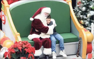  ?? ?? A boy gets a hug from Santa Claus on Black Friday at the Danbury Fair mall.