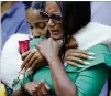  ?? JOHN MINCHILLO/ ASSOCIATED PRESS ?? Mourners embrace as they stand beside the north pool during Saturday’s ceremonies in New York.