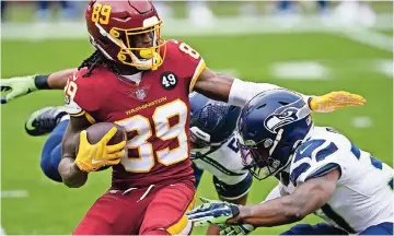  ??  ?? cam sims (89) es tacleado por Quandre Diggs (37) y K.J. Wright (50)